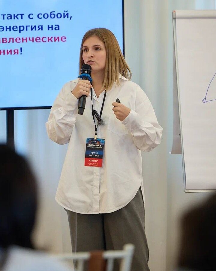 Ирина Анохина выступает с микрофоном